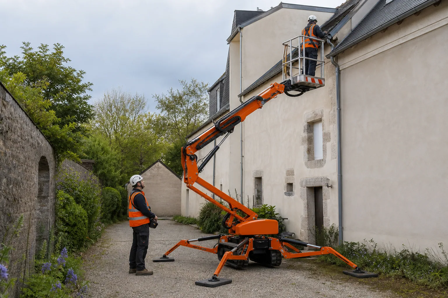 Une nacelle élévatrice orange intervient sur un bâtiment avec un technicien dans le panier et un opérateur au sol, dans le secteur de Pontivy.